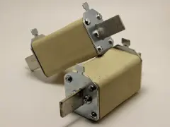 Dwa ceramiczne wyłączniki nadprądowe z metalowymi stykami, gotowe do ochrony instalacji elektrycznej.