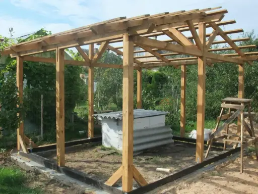 Drewniana altana ogrodowa zrób to sam w trakcie budowy. W środku betonowa konstrukcja, obok drabina.