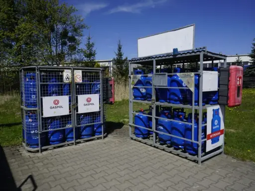 Butle z gazem Gaspol stoją w metalowych stojakach. Zastanawiasz się, ile kosztuje butla z gazem? Sprawdź cenę wymiany.